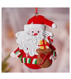 Macro view of Santa Claus gingerbread ornament with golden gift bag and candy cane details