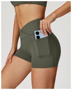 Detail of high-waist olive yoga shorts with V-cross waistband and side phone pocket