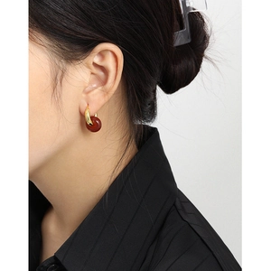 Pendientes de aro de plata S925 con dijes de color rojo oscuro mostrados en modelo