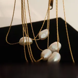 Macro shot of multi-layer gold chain necklace with irregular baroque freshwater pearls