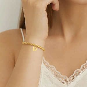 Bracciale a catena intrecciata in oro 18 carati con ciondolo lettera D al polso donna
