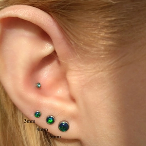 Detail view of G23 titanium opal labret studs in 3mm 4mm and 5mm sizes on ear