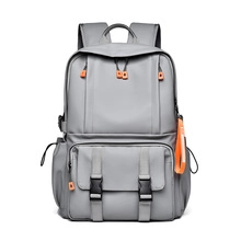 Détails du sac à dos à carreaux gris avec zips orange et poches à boucles noires