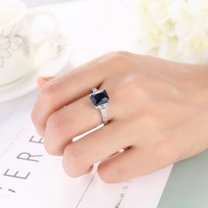 Elegant woman wearing a royal blue square zircon ring in a stylish lifestyle setting