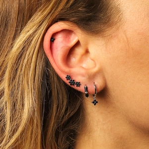 Macro detail of S925 silver stud earrings with black zircon four-leaf clover design