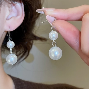 Detailed shot of French style double pearl drop earrings with elegant silver hooks