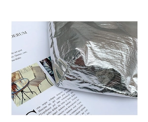 Close-up of the silver nylon fabric with a metallic foil texture and stitched details
