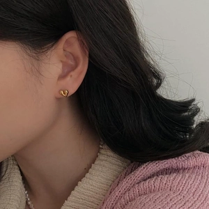 Elegant 925 sterling silver heart-shaped stud earrings in gold worn by a model