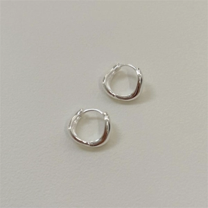 Détail macro de boucles d'oreilles créoles courbes en argent 925 poli miroir brillant