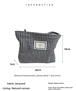 Detail showing houndstooth fabric makeup bag with 26x18x5cm size markings and zipper