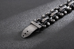 Macro shot of industrial retro men's bracelet with braided black leather and steel links
