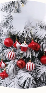 Detailed view of red and white Christmas ornaments hanging on a snowy festive tree branch