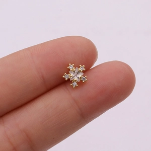 Macro shot of a rose gold star earring with micro-set zircons on a finger