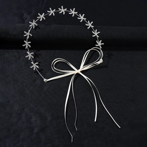 Detail view of bridal starfish headband with rhinestones and white silk ribbon bow