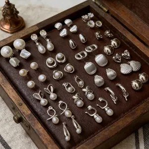 Collection of French vintage pearl and diamond stud earrings in a wooden jewelry box