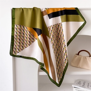 70cm houndstooth silk-like scarf in olive and mustard yellow hanging on a rack