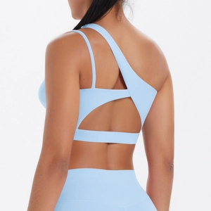 Detail of light blue asymmetrical yoga bra featuring unique single shoulder strap design