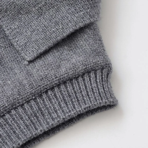 Close-up of loose-fit dark grey knit sweater with high-density ribbed texture details