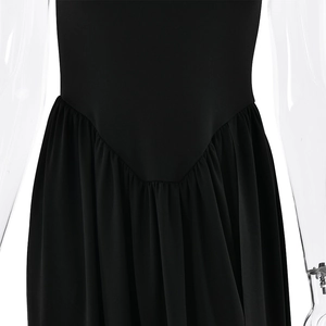 Close-up detail of the waist design and flowing fabric on a black backless maxi dress