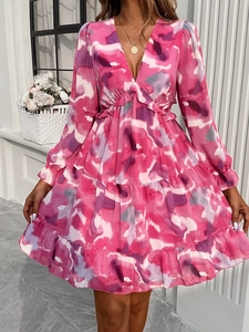 Detailed view of women's elegant V-neck dress with abstract pink floral print and ruffled hem