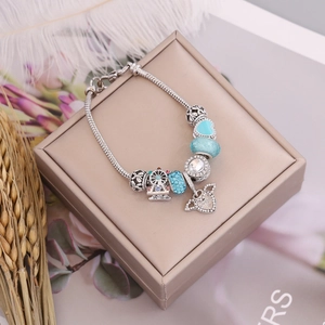 Detail of silver snake chain bracelet with sky blue charms and Ferris wheel pendant