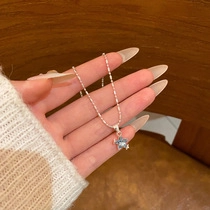 Detailed shot of a silver star pendant featuring a light blue gemstone on a fine chain