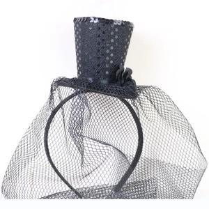 Detail of black sequined mini hat headband with mesh veil and floral accents