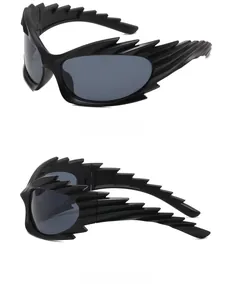 Detail view of avant-garde wing-shaped sunglasses with black frame and grey lenses