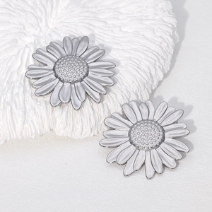 Minimalist sunflower earrings in silver finish on a textured decorative white background