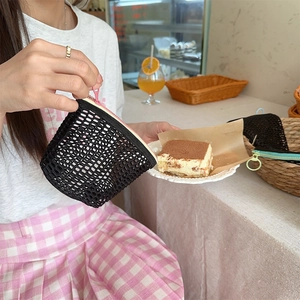 Detailopname van een zwart gaasje opbergzakje met roze rits in een gezellig café
