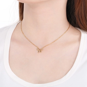 Minimalist golden stainless steel bow necklace for women shown on a fashion model