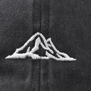 Distressed black cotton baseball cap with white embroidered mountain peak logo details