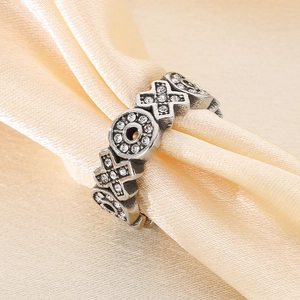 Retro stainless steel ring with pavé-set XO design on elegant champagne silk background