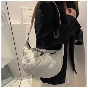 White quilted half-moon crossbody bag with elegant diamond stitching and wide strap
