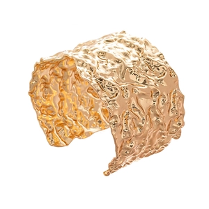 Modern wide gold cuff bracelet with irregular wrinkled texture and geometric open design