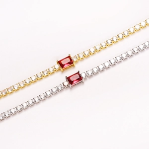 Detailed close-up of gold and silver tennis bracelets with rectangular red center gemstones