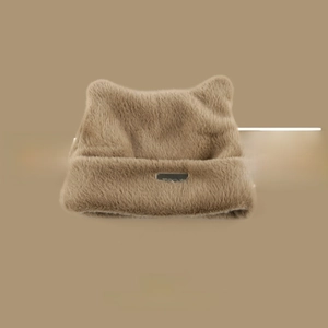 Detailed view of soft brown faux fur knit hat with cat ears and gold metal logo