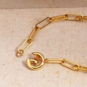 Close-up of gold-plated paperclip chain necklace with a unique round spring clasp