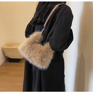 Stylish light brown faux fur shoulder bag with leather strap worn by a model