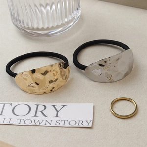Close-up of metallic ponytail holders with irregular hammered texture in gold and silver