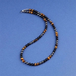 Detailweergave van drievoudige beschermingsketting met tijgeroog, hematiet en onyx kralen