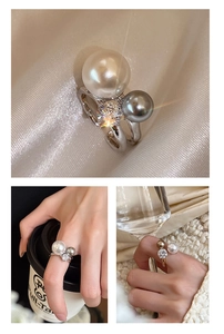 Macro detail of silver ring featuring dual pearls and sparkling zircon on silk background