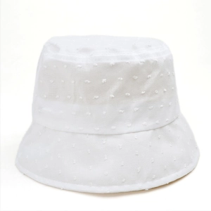 Détail d'un chapeau bob blanc avec motif à pois texturés et dessus plat design