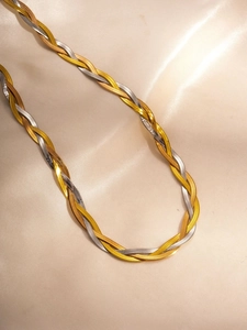 Macro view of a tricolor braided flat snake chain necklace in gold, silver, and rose gold