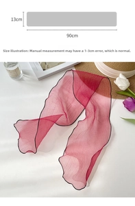 Detailed view of red organza scarf measuring 90cm by 13cm with fine black hemmed edges