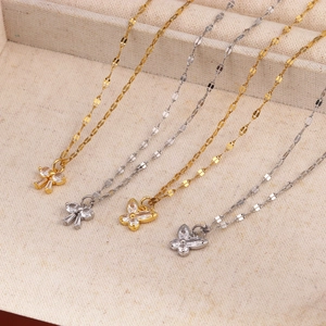Détail de pendentifs papillon en or et argent avec zircons sur des chaînes à pétales fins