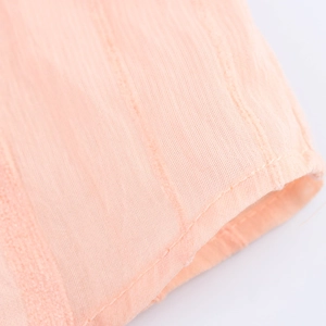 Detail of pink striped shirt fabric showing fine texture and neat stitching on cuff