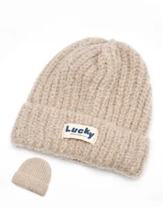 Close-up of knit beanie texture and Lucky patch on soft khaki warm winter hat