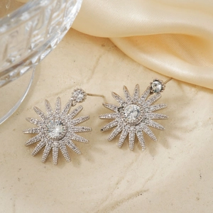Elegant silver starburst drop earrings featuring premium cubic zirconia on silk fabric