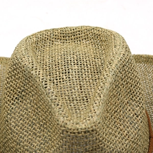 Close-up detail of the woven texture and crown structure of a natural straw cowboy hat
